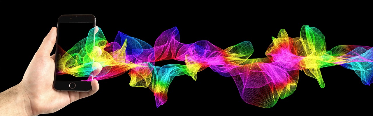 A hand holding a smartphone with colorful, abstract light waves flowing out of the screen.